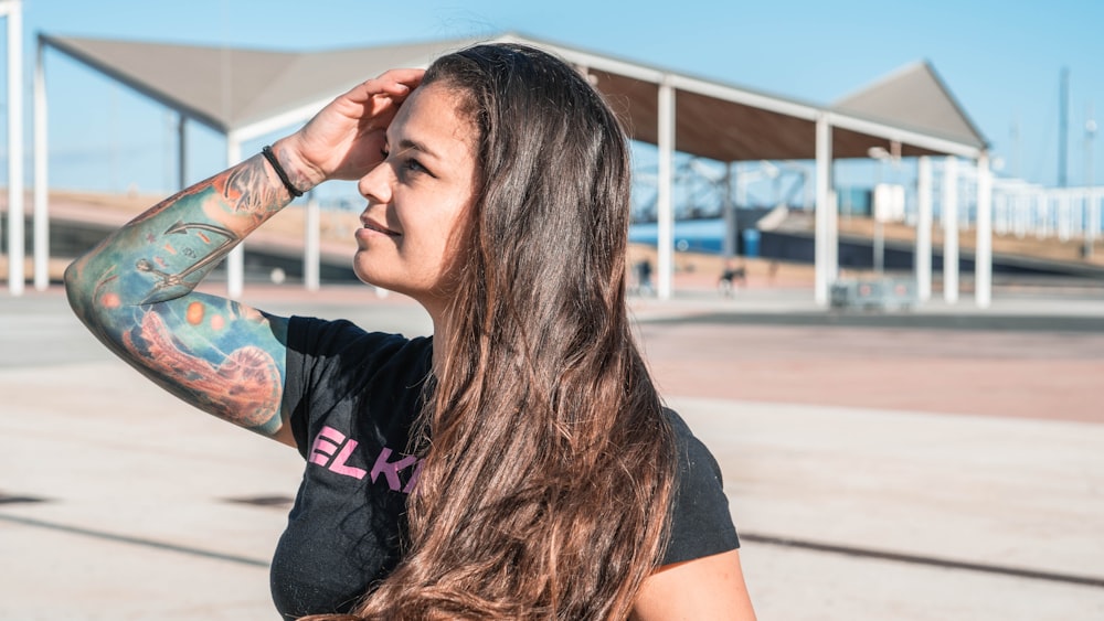 woman in black t-shirt holding her hair