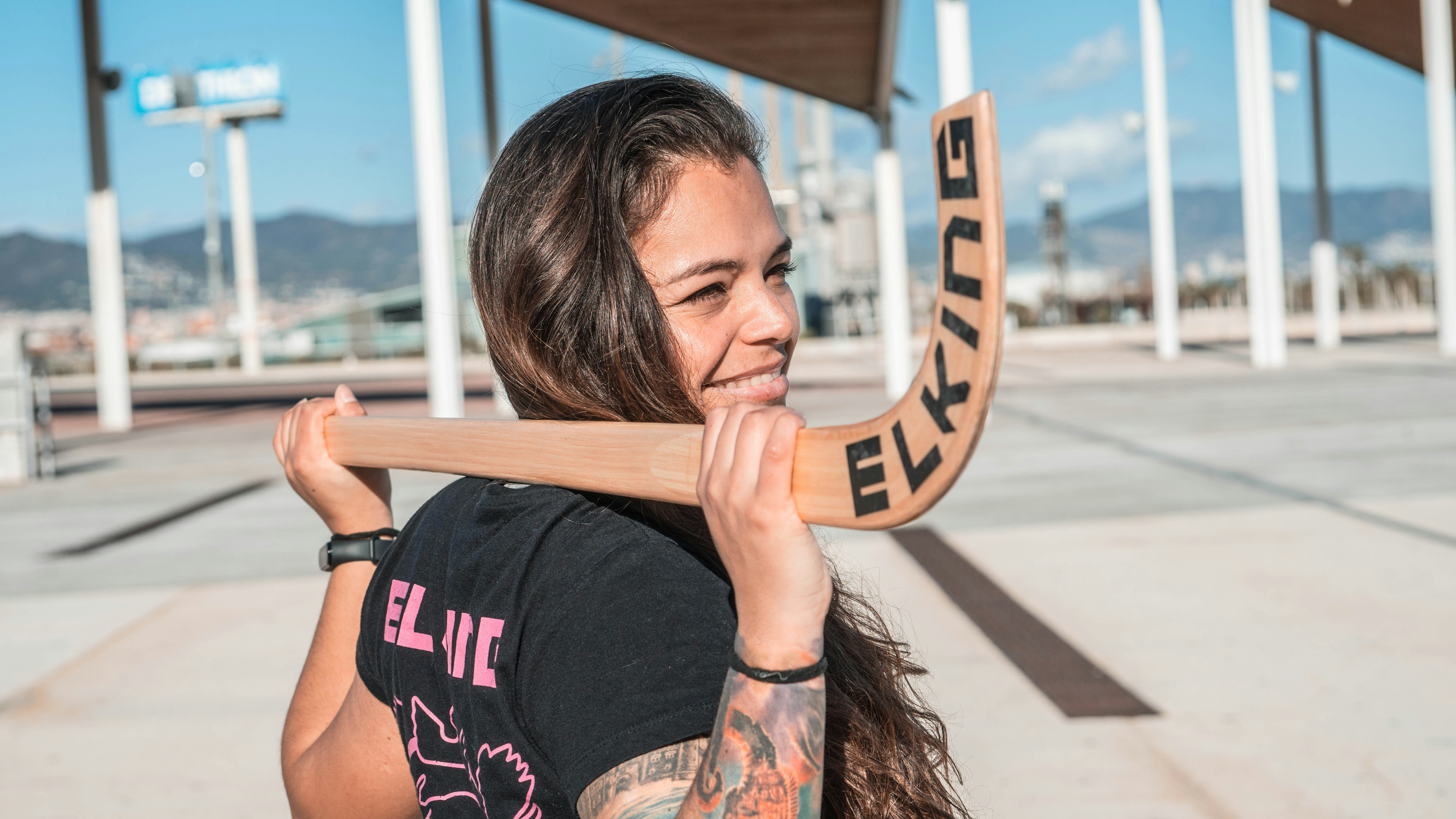woman in black and red crew neck t-shirt holding brown wooden frame