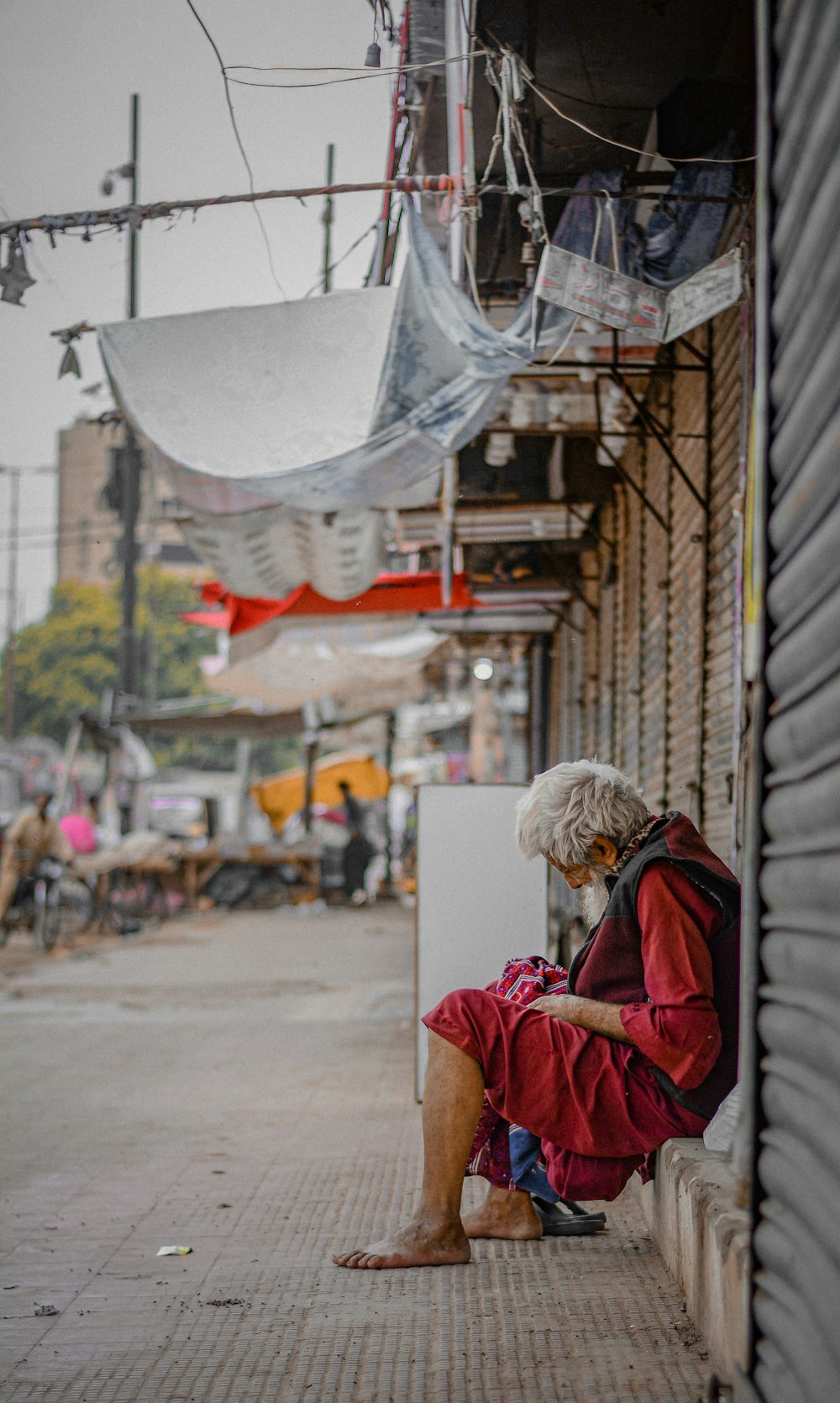 woman in red jacket and brown knit cap standing near building during daytime