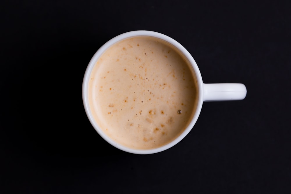 white ceramic mug with brown liquid