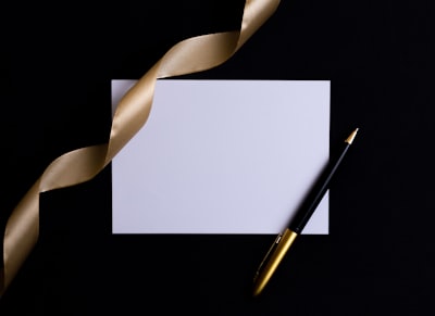 black and gold pen on white paper ribbon zoom background