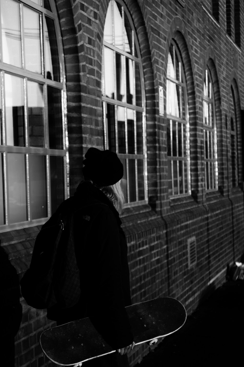 person in black jacket standing near window