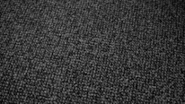 Close-up of a matte black fabric textured with subtle circuitry patterns glowing faintly.