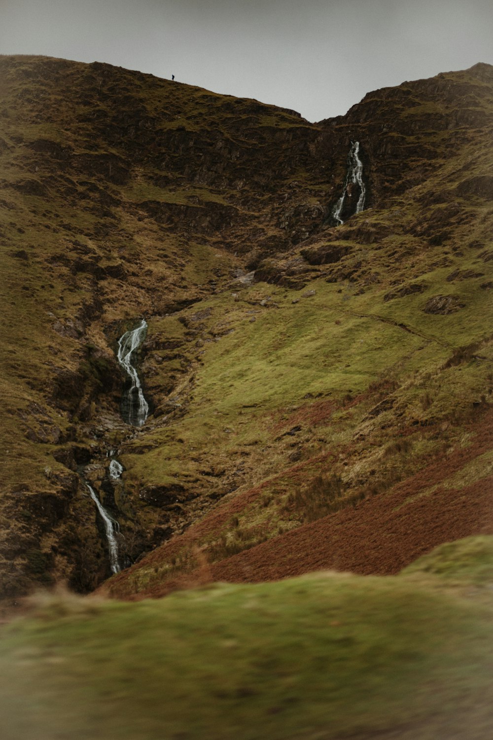 green and brown mountain with water falls