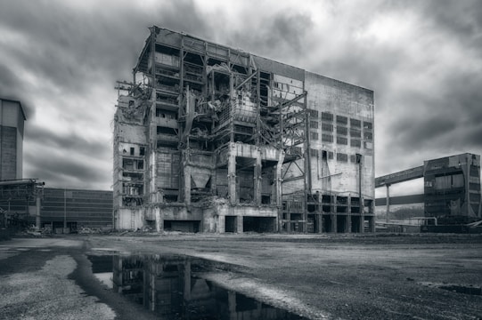 A dark, ominous shadow looming over a crumbling corporate building.
