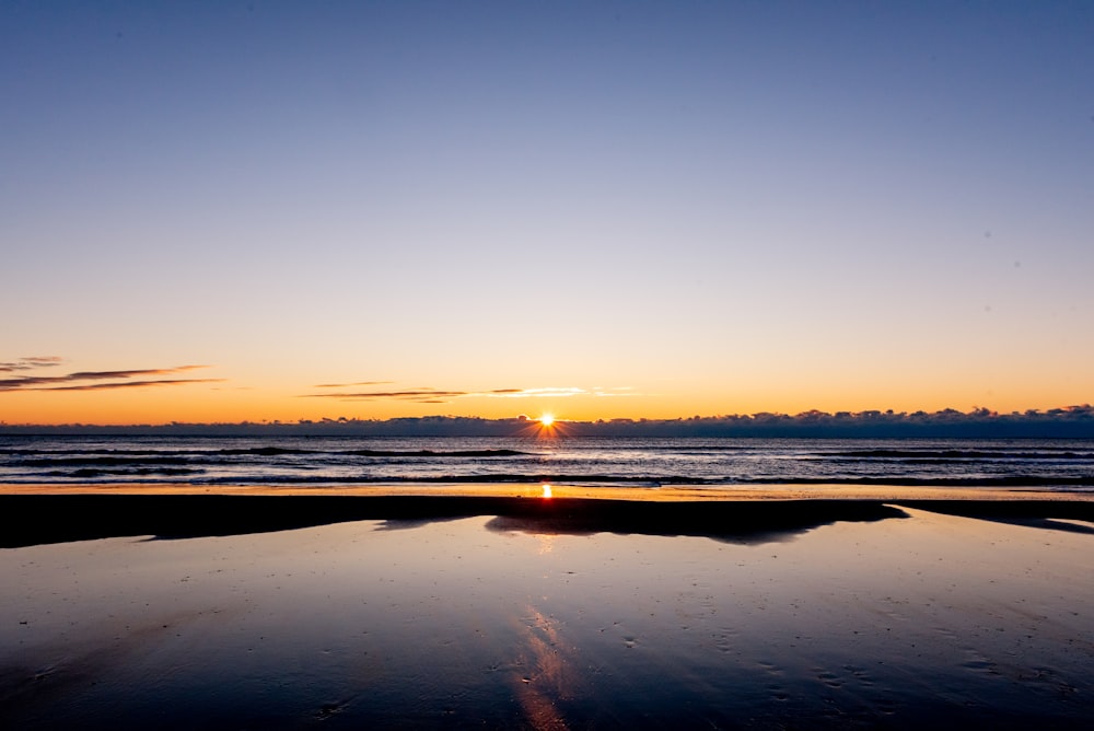 mar en calma bajo el cielo azul durante la puesta del sol