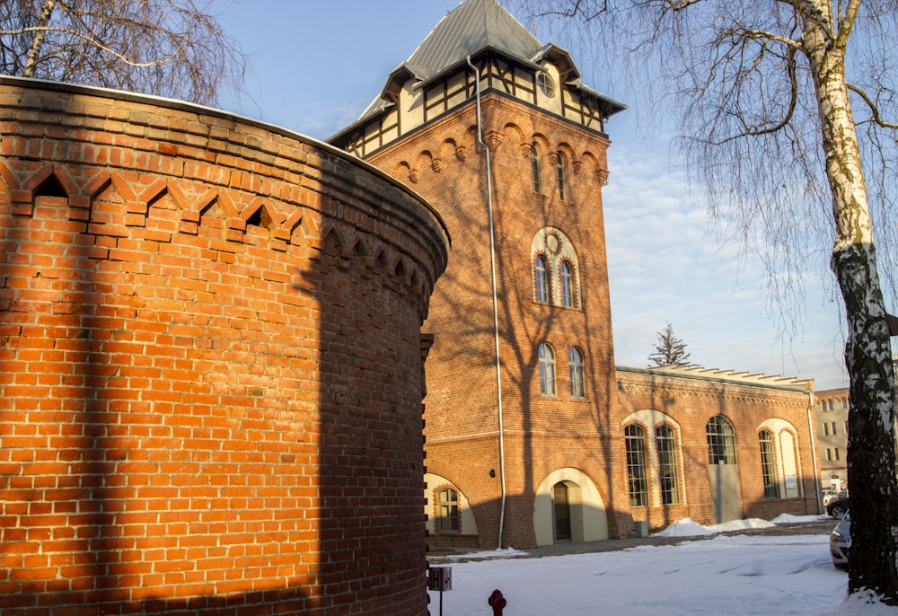 brown brick building near bare trees during daytime