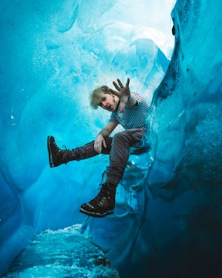 man in black and white striped shirt and blue denim jeans floating on water