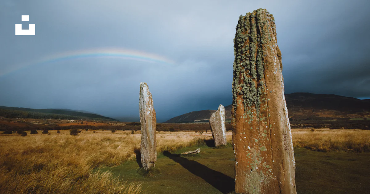 Gray rock formation on brown grass field under white clouds during ...