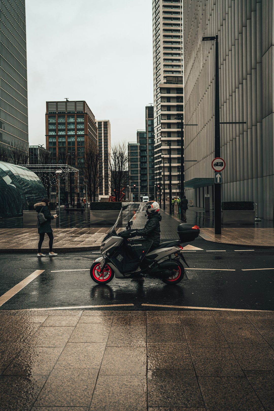 man in green jacket standing beside black and red motorcycle during daytime