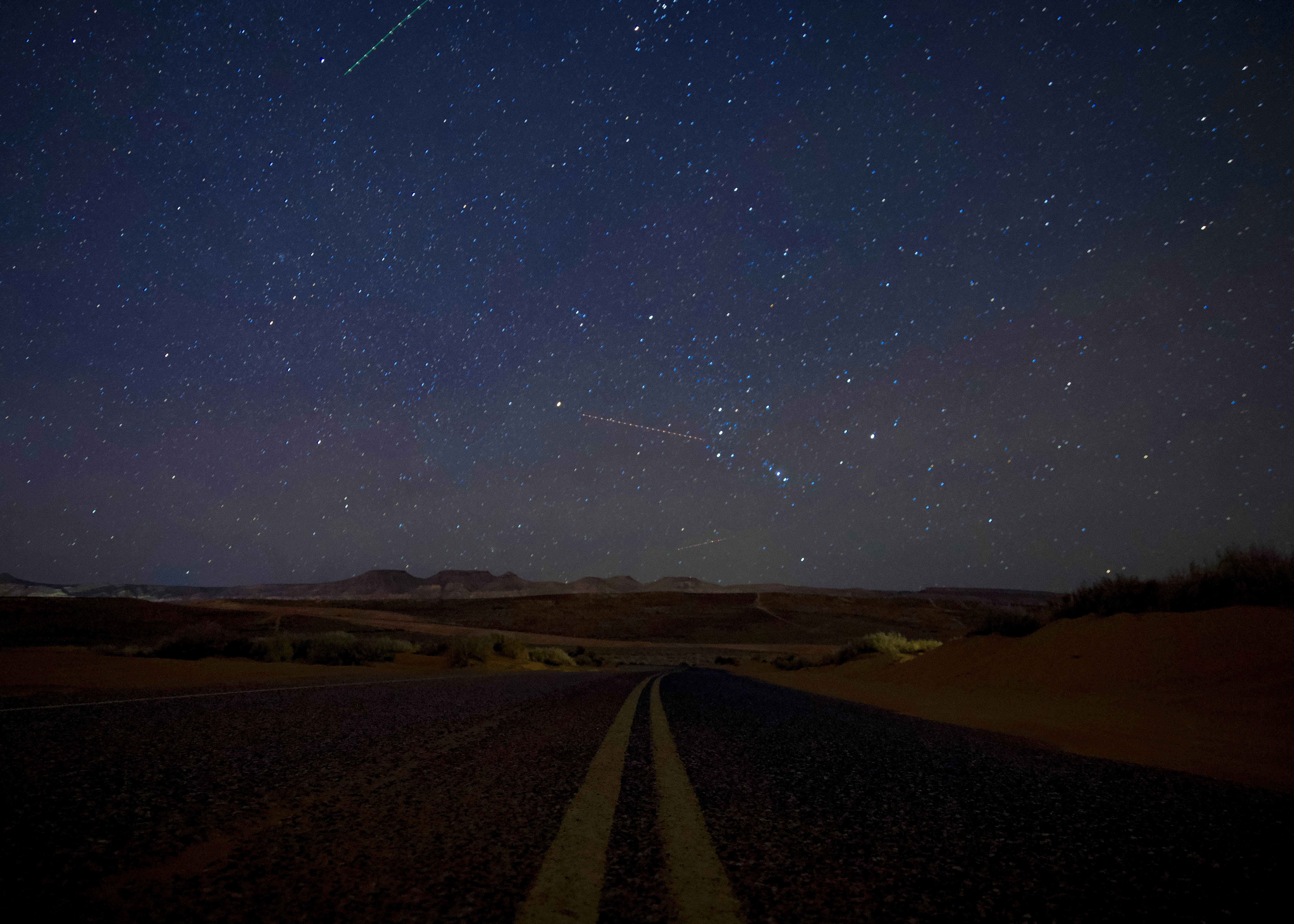 black asphalt road under blue sky during night time