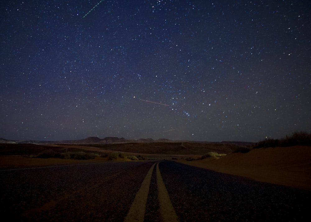 black asphalt road under blue sky during night time