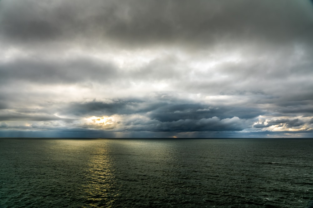 body of water under cloudy sky during daytime