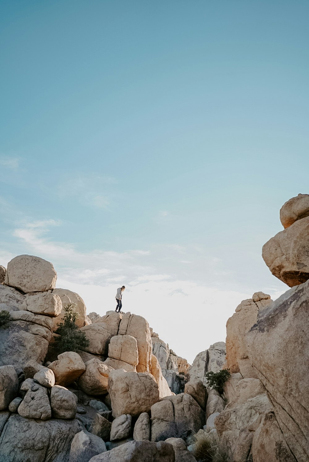 person standing on rocky mountain during daytime