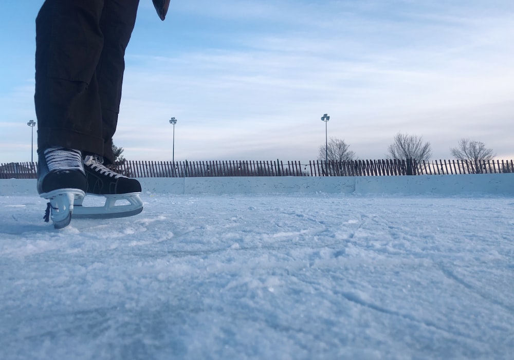 person in black pants and black shoes standing on snow covered ground during daytime