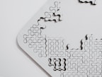 Close-up of uniquely shaped puzzle pieces fitting together on a wooden surface.