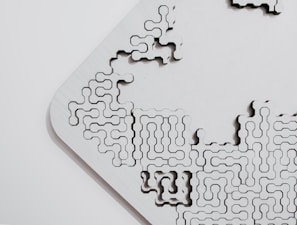 Close-up of a finely detailed wooden laser-cut puzzle piece.
