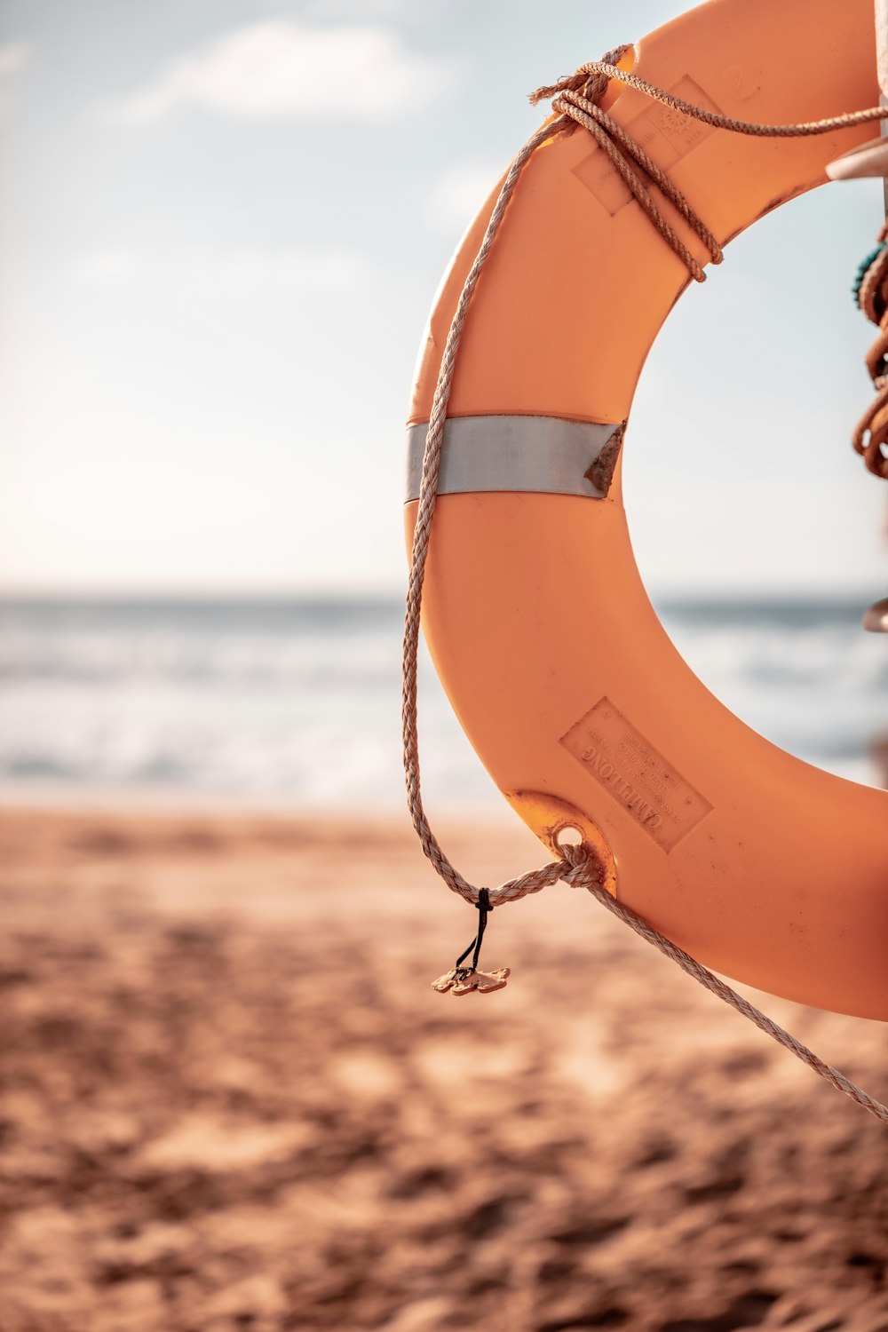 orange life buoy on beach during daytime