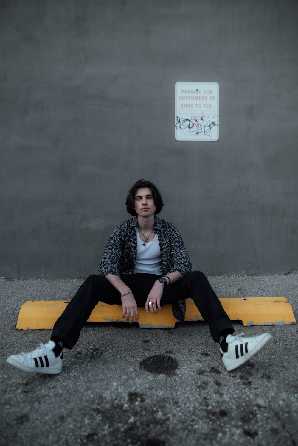 a man sitting on a yellow bench in front of a wall