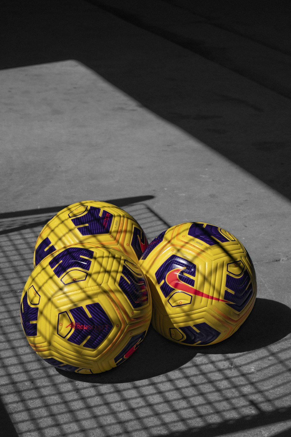yellow and black soccer ball on gray wooden floor