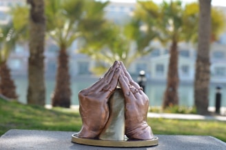 An artistic rendering of intertwined hands in prayer, rendered with delicate brush strokes and warm tones.