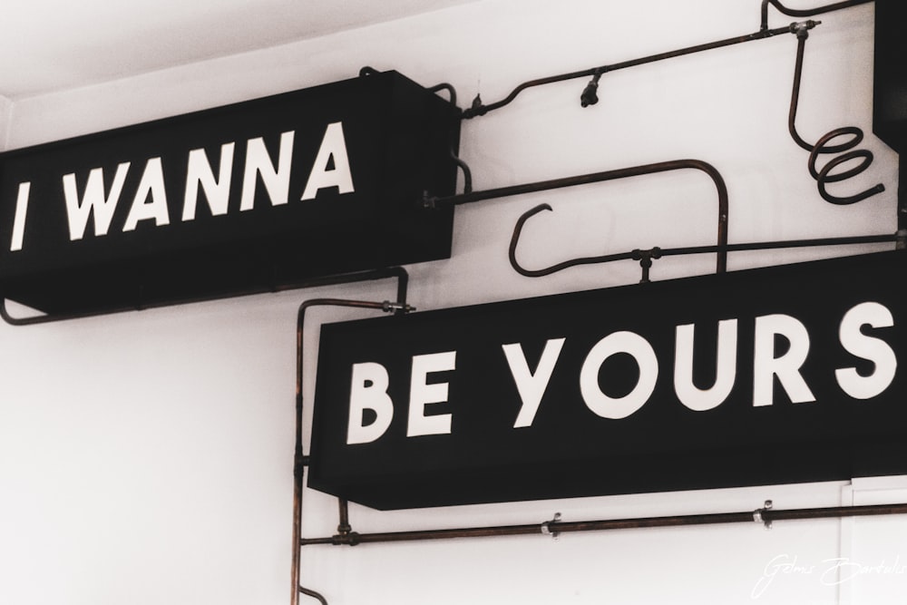 a couple of black and white signs hanging from the side of a building