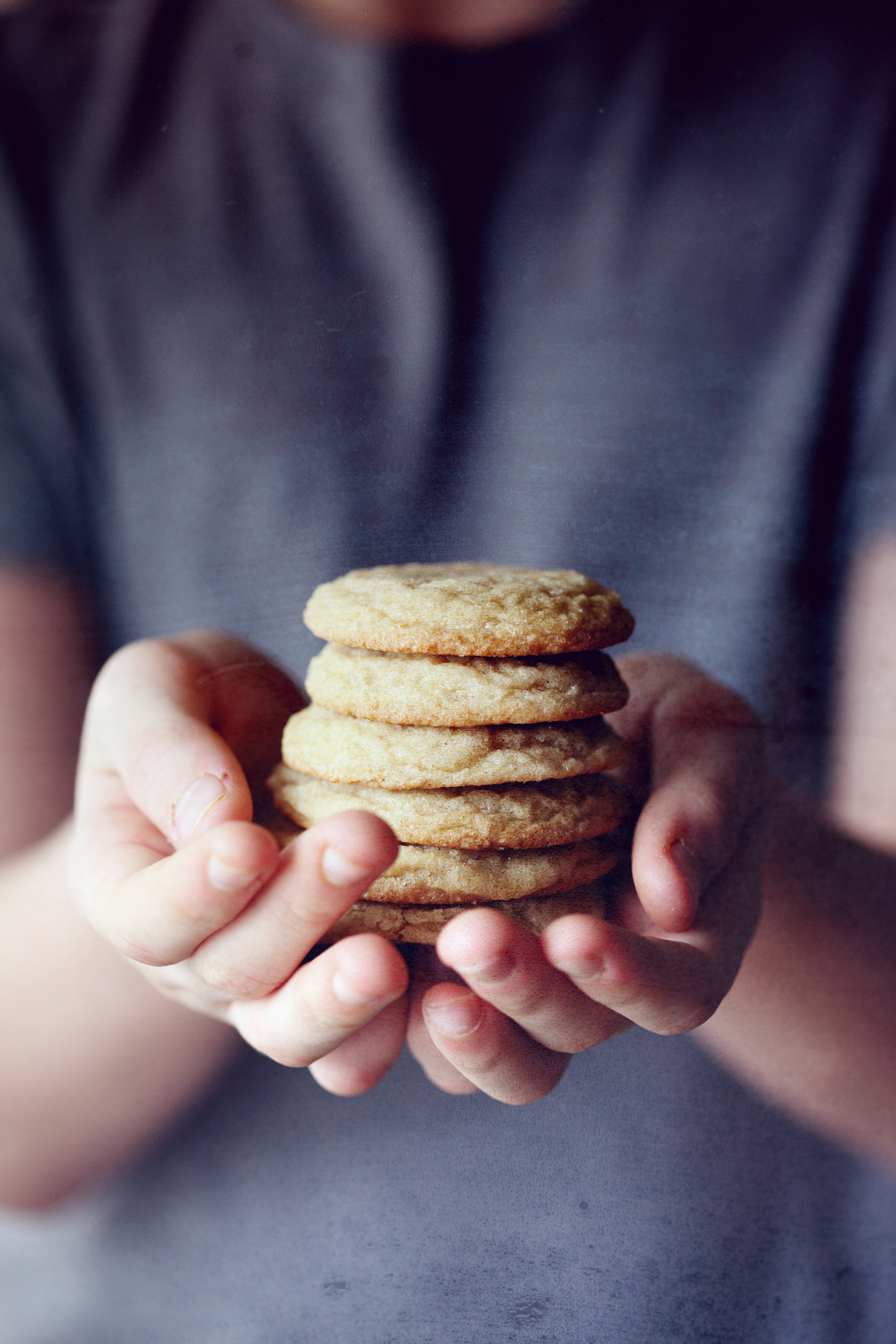 Child holding freshly baked sugar cookies.