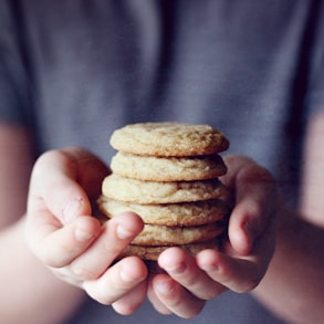 person holding brown cookies in close up photography