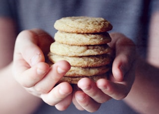 person holding brown cookies in close up photography