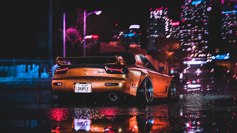 orange porsche 911 on road during night time