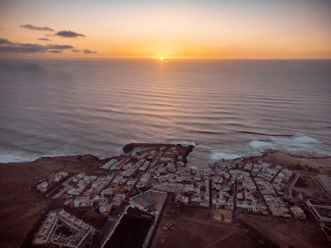 houses near sea during sunset