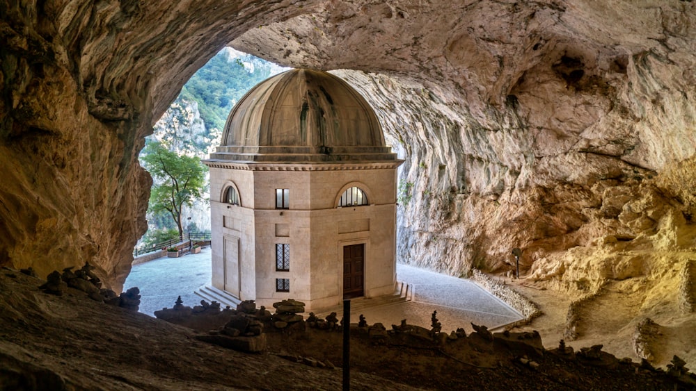 Bâtiment en forme de dôme en béton brun près d’un plan d’eau pendant la journée