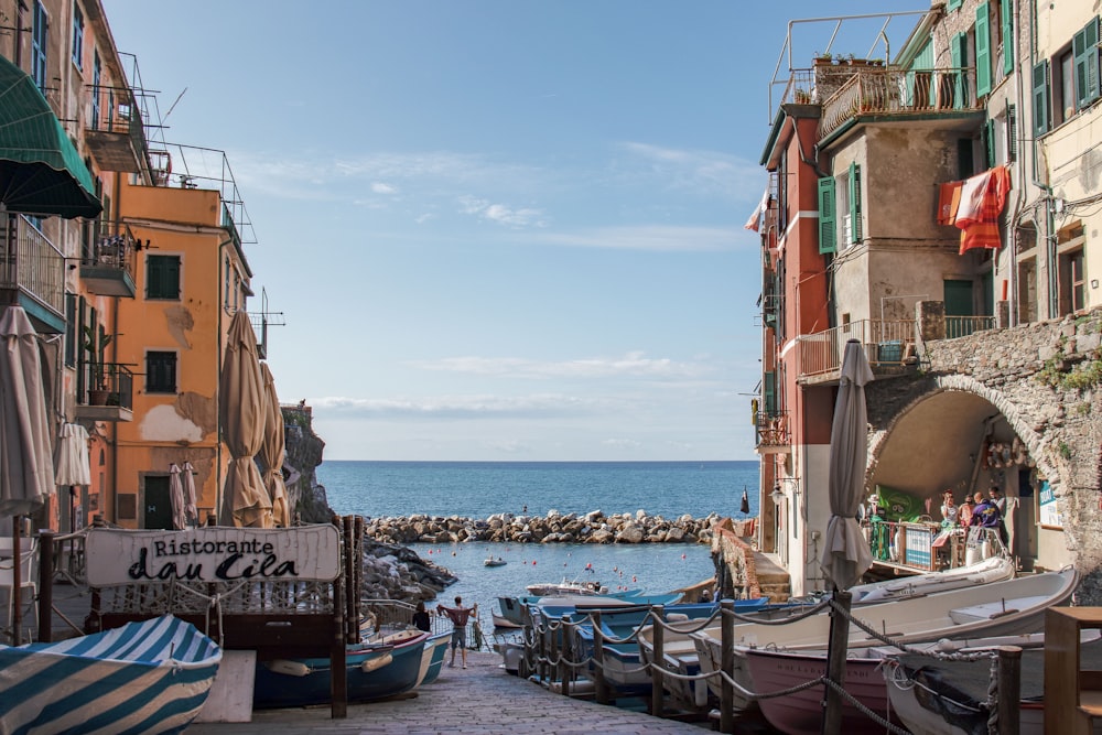 boats on sea near buildings during daytime