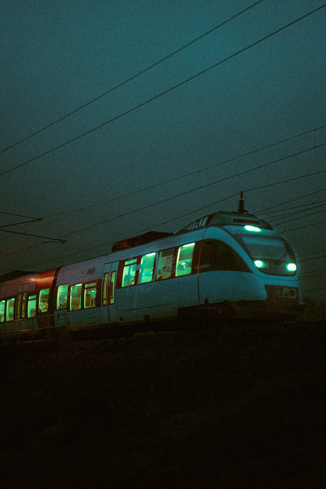 white and blue train on rail during night time