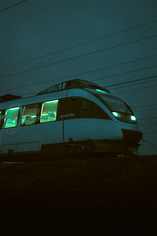 A sleek futuristic train speeding along glowing neon tracks under a twilight sky.