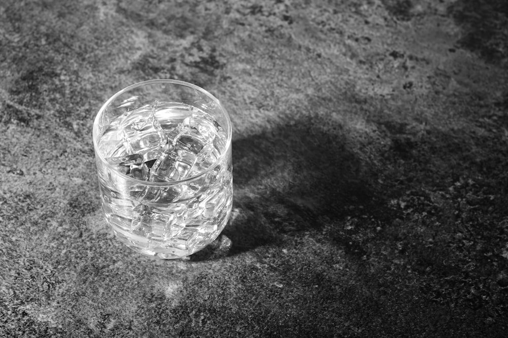 clear drinking glass on black and white textile