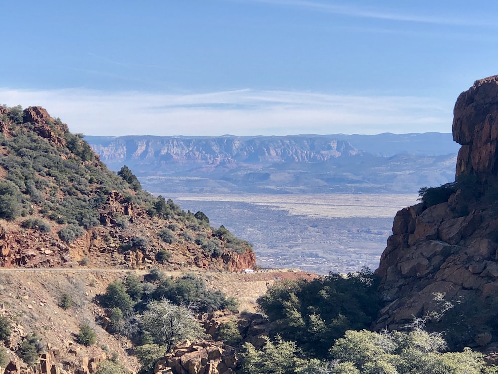 brown rocky mountain near body of water during daytime