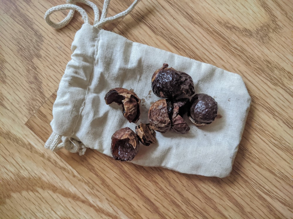 brown and black stones on white textile