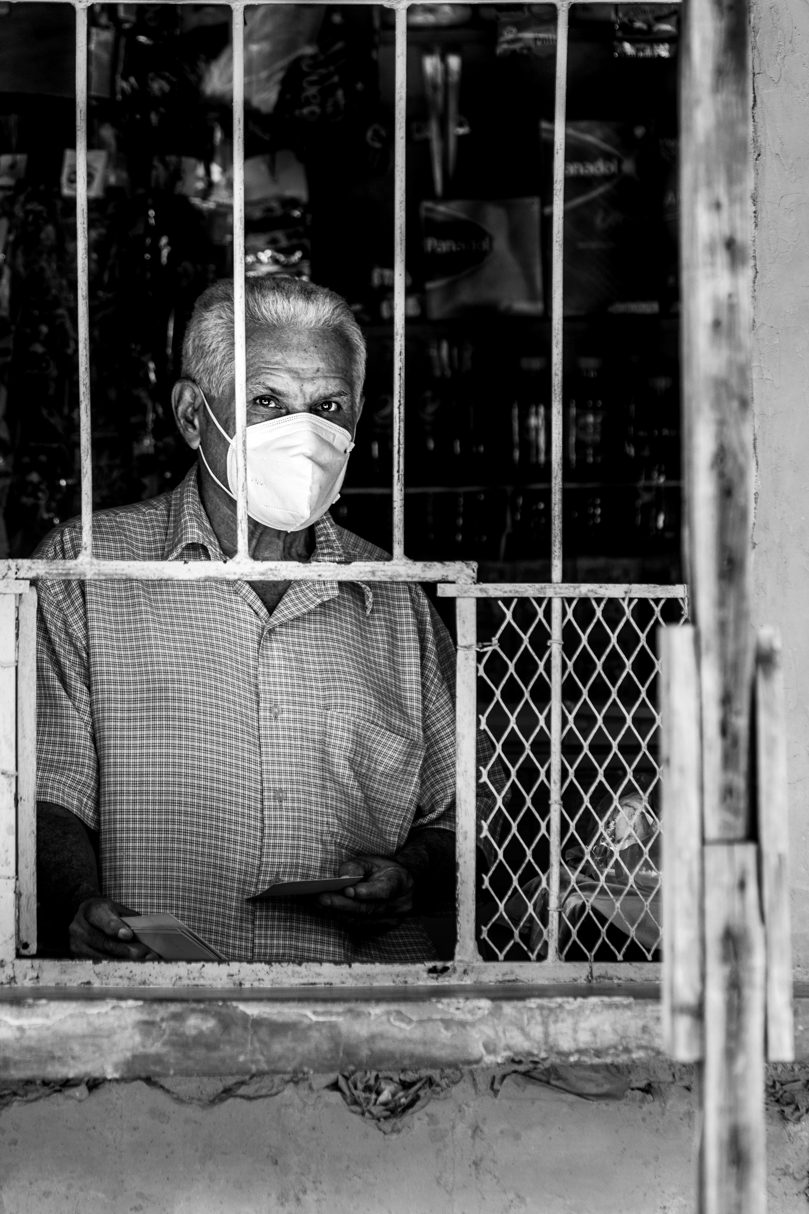 man in white and black checkered button up shirt standing beside metal fence
