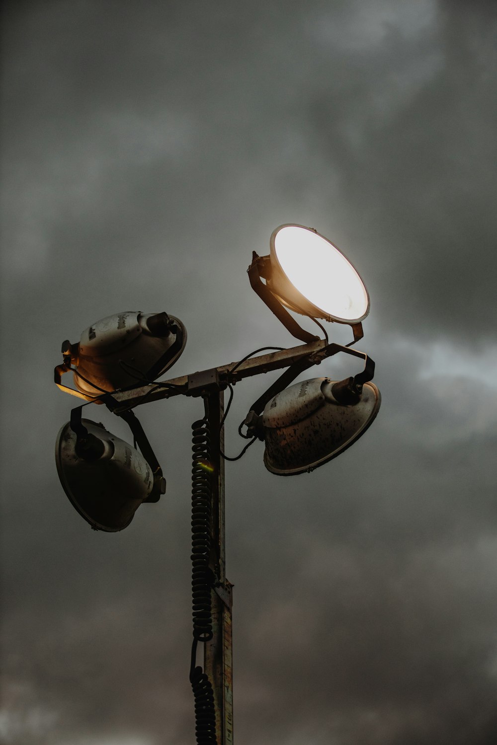 silhouette of light post under cloudy sky during daytime