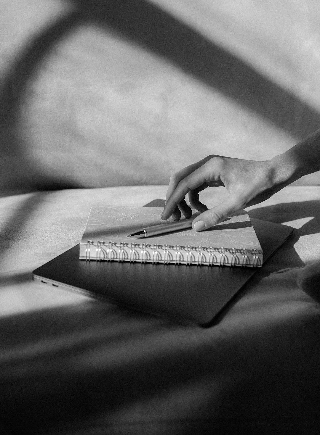 grayscale photo of persons hand on book