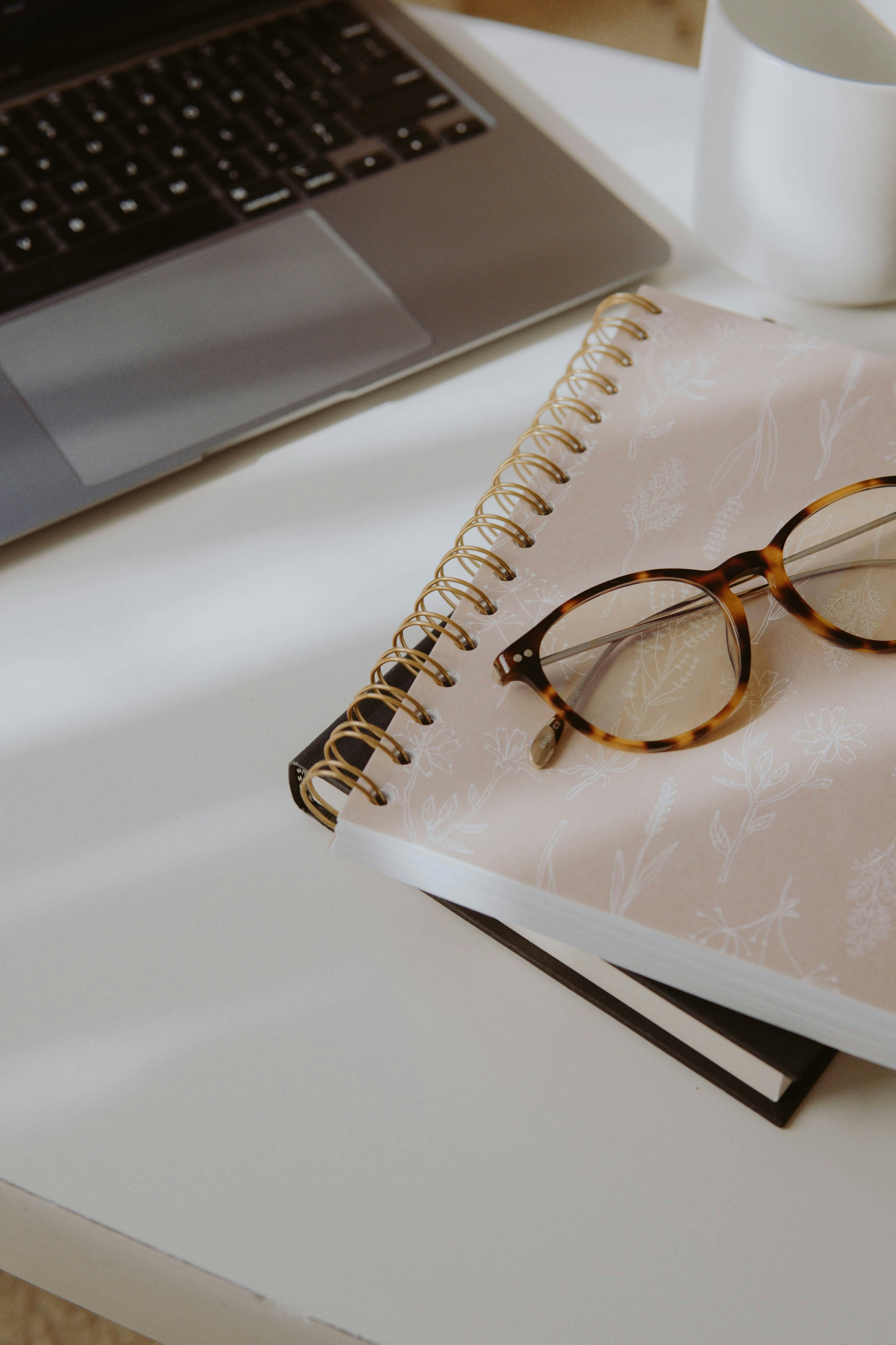 brown and black framed eyeglasses on white notebook