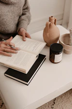 person in gray sweater holding white paper