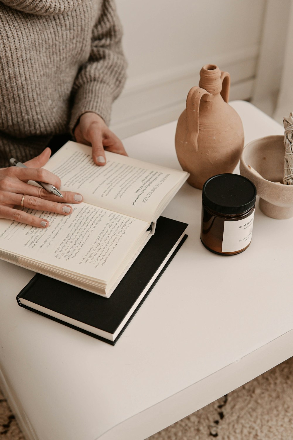 person in gray sweater holding white paper