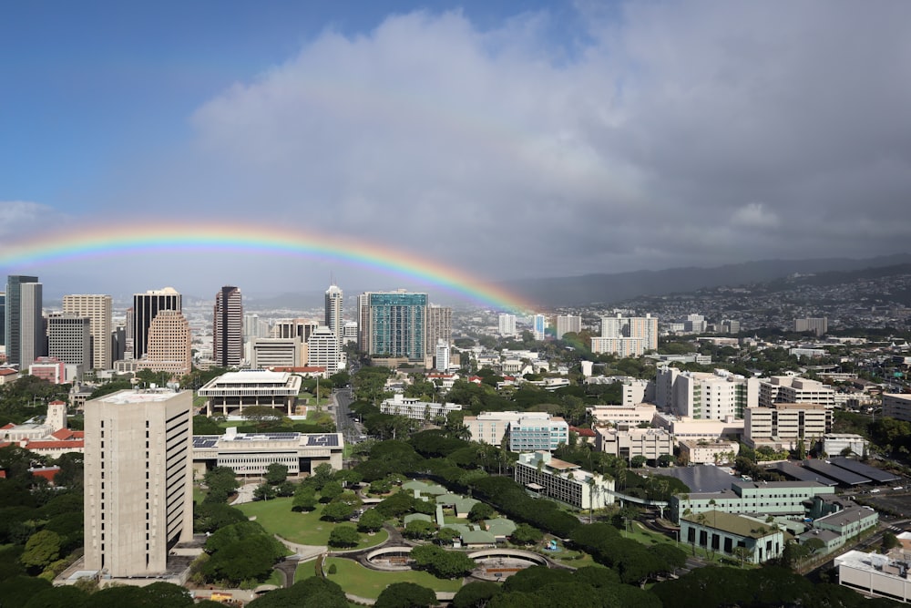 rainbow over city buildings during daytime
