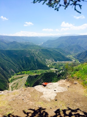 A breathtaking panoramic view of Guizhou's lush green mountains and traditional villages under a clear blue sky.
