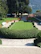 A beautifully landscaped lakefront garden with vibrant flowers and manicured lawn.
