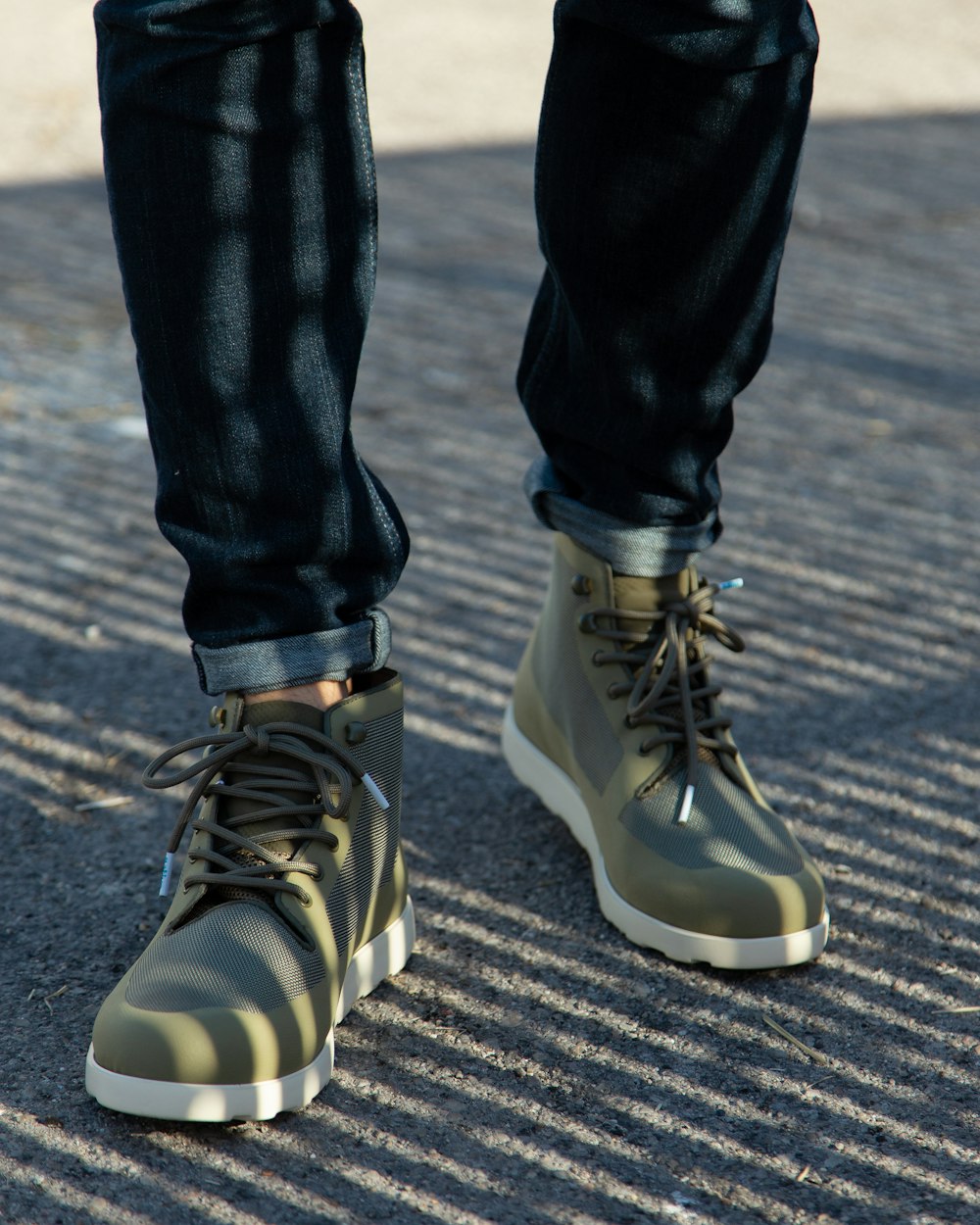 person in black pants wearing black and white adidas sneakers