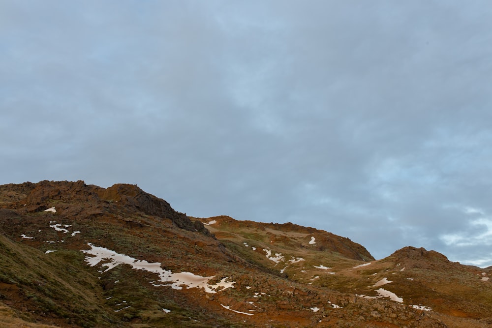 montagna rocciosa marrone e grigia sotto il cielo nuvoloso bianco durante il giorno