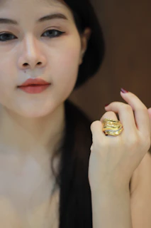 Close-up of a woman’s hand wearing a gold-plated ring with a subtle shimmer.